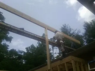 Carpenter setting a ridge beam over a new addition frame — Ice Dam Removal by Roofing Brothers in Belle Center