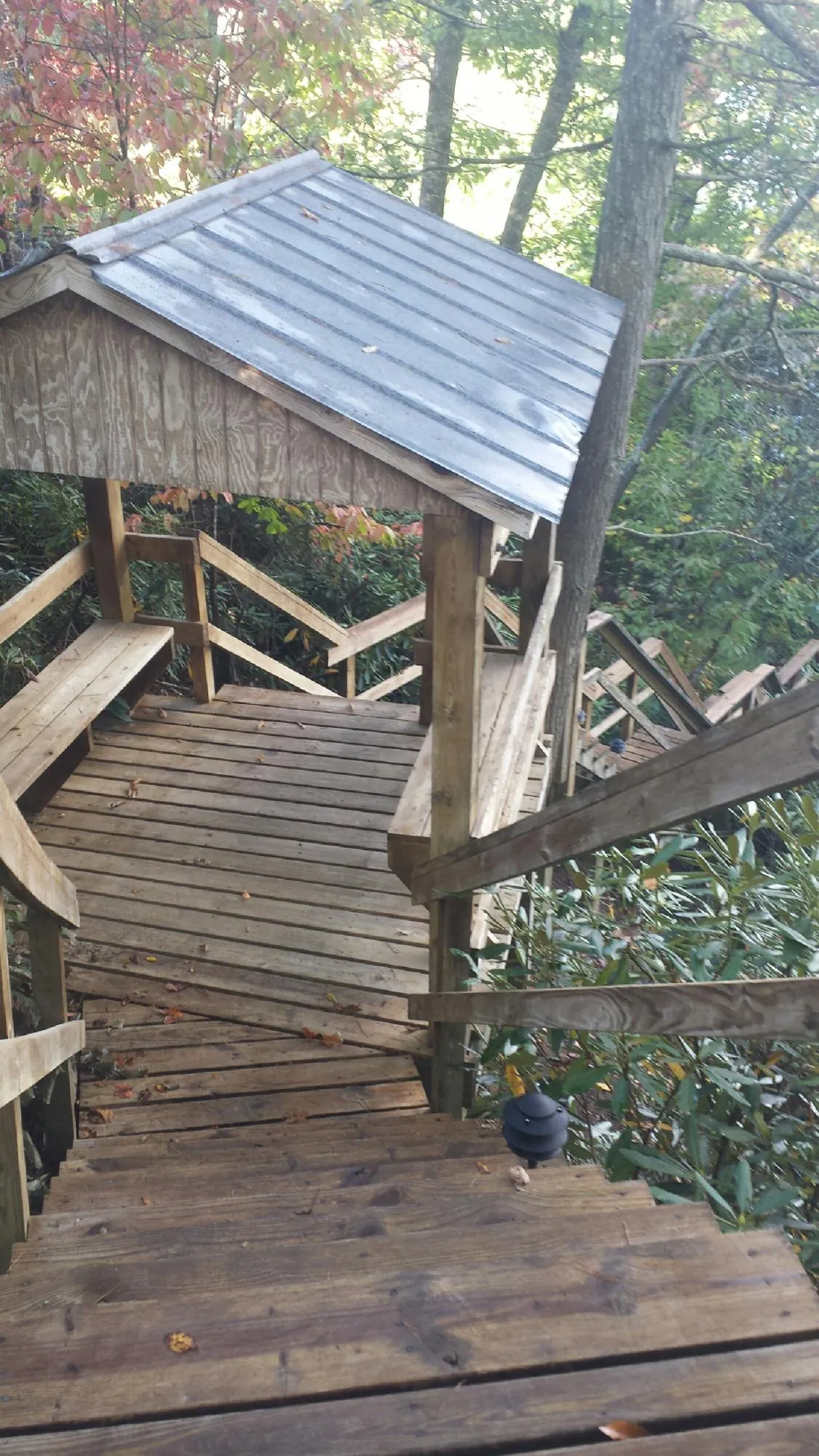 Metal roofed shelter over wooden steps on a wooded walkway — Skylight Repair & Installation work by our crew in Belle Center