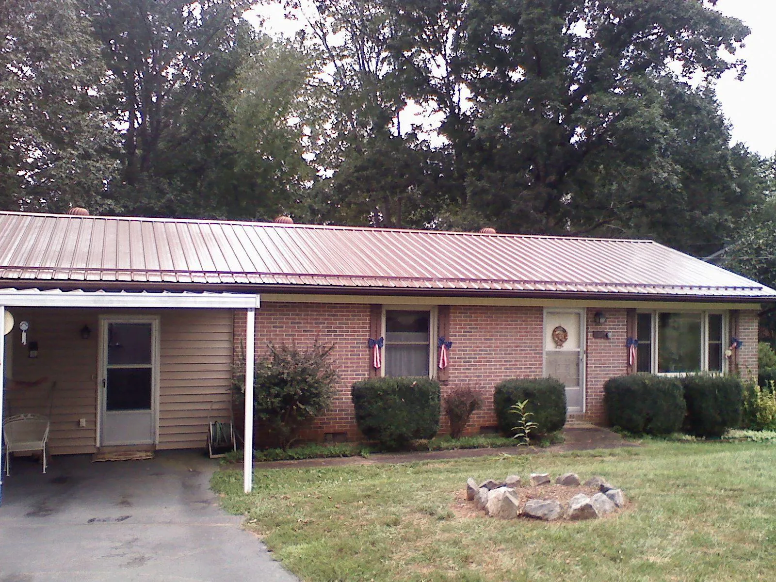 Bronze metal roof and carport on a brick ranch home — Roof Repair work by our crew in Belle Center